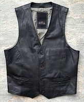 Front view of black leather vest showing full body, buttons, and pockets.