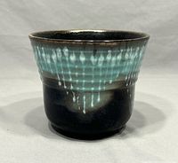 Front view of Vintage Scheurich planter showing turquoise drip glaze on dark base with glossy finish