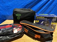 Lot overview showing all items together: Slime tire repair kit, booster cables, and Goodyear dual flow digital inflator box