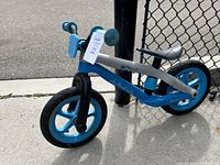 Side view of Chillafish Monster BMXie balance bike showing blue wheels, gray handles, and black seat.
