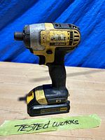 Side view of the used DeWalt 20V Max impact driver with 20V battery pack, showing wear and tested working note.