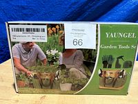 Box front showing garden tools set with image of elderly couple gardening and storage tote with tools inside.