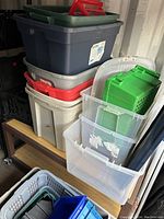 Photo of stacked plastic totes and bins of various colors and sizes, showing tops and sides, with some dust and dirt visible.