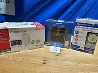 Front view of the three boxed items: Honeywell Prestige IAQ Kit, Honeywell T5-WiFi thermostat, Intermatic 24 Hour Mechanical Time Switch.