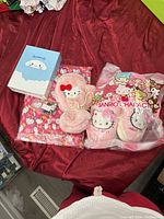 Photo of the pajama set, slippers, mittens, and night light box placed on a red fabric background.