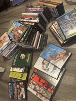 Top view of assorted DVD cases arranged on floor with visible movie titles and cover images.