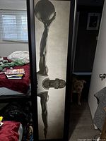 Full long vertical portrait photo of Michael Jordan in black and white, showing his outstretched arms and basketball above his head, leaning on a bed and window background.