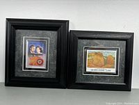 Two black framed limited edition stamps side by side: Vincent van Gogh haystack and Burns and Allen images.