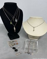 Photo of all items in lot including 5 necklaces on stands, 3 pairs of earrings, 2 bracelets, and 1 ring arranged on tabletop