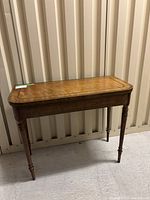 Front view of closed table showing veneer top and turned legs