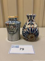 Two hand painted pottery vases by Aitken & Hyde displayed together, showing front decorations and sizes.