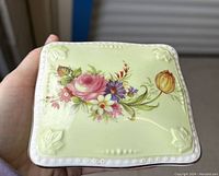 Top side of a Foley bone china trinket dish showing pale green background with colorful floral bouquet and white beaded border