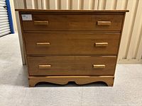 Front view of the mid-century 3-drawer maple dresser showing the wood grain, drawer handles, and overall design.