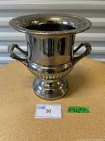 Silver plated urn with flared rim, two handles, round base.
