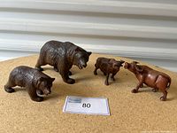 Four wooden animal figurines on display, two bears and two oxen, showing overall lot condition and variety.