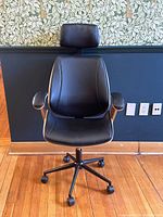 Front view showing padded seat, backrest, headrest and five-star caster base.