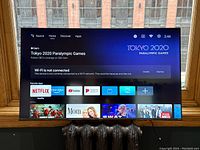 Front view of TV powered on showing home screen interface and condition