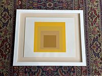 Overhead shot of entire framed serigraph print on patterned rug