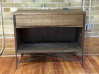 Front view of wooden West Elm console table showing single drawer and open storage below