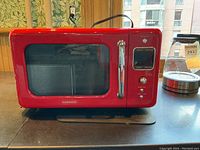 Front view showing cherry red color, large glass window, chrome handle, digital display and control buttons