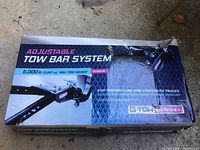 Box showing Adjustable Tow Bar System branding, max tow weight 5,000 lbs, Class III for towing cars and light-duty trucks.