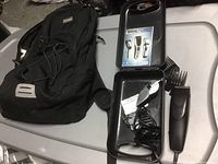 Black fabric backpack and Wahl hair clipper set in metal case on table