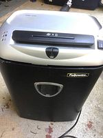 Front view of the Fellowes paper shredder with paper slot, control buttons and power switch. The shredder bin is missing.