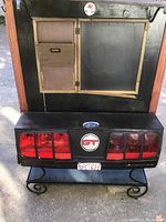 Front view of the handmade cabinet showing upper door and mail slots and lower section designed with Ford GT tail lights and badges