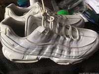 Side view of white Nike Airmax men's sneaker showing mesh and synthetic overlays, visible dirt and wear on the sole and upper.