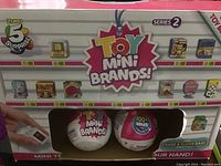 Toy Mini Brands Series 2 packaging showing 2 collectible toy eggs and illustrations of miniature branded items for collection