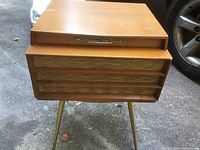 Front view of vintage wooden RCA Victor Orthophonic High Fidelity phonograph on angled legs showing woven speaker grille front.