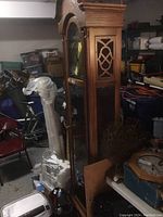 Full view of the tall vintage Ridgeway grandfather clock in wooden case, showing decorative lattice front and pendulum area.