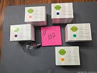Six Scentsy light bulbs in their original boxes arranged on a table, one bulb partially visible outside the box.