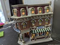 Porcelain Sears store building village piece lit up showing detailed windows and Sears signage.