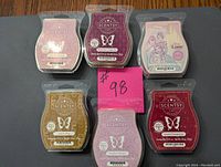 Photo showing all 6 new Scentsy wax bars arranged in two rows with label details visible.
