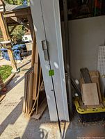 Full length view of the black Shimano fishing rod leaning against a wall showing the rod's length and slim profile.