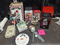 Overview of the entire snowman collection including figurines, mini tea sets, wind chime, music boxes, and decorative plate.