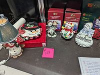 View of entire snowman collection including plate, two figurines, musical figurine, and lamp.