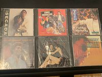 Front view of six sealed music CDs featuring artists Jon Secada, Ennio Morricone, Stevie B, Engelbert Humperdinck, Shaggy, and another female artist.