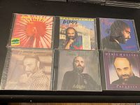 Front view of six Demis Roussos CD covers, each showing different album artwork and photos of the artist.