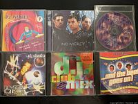 Top view showing the front covers of six music CDs; D.J. Pierres, No Mercy, DJ Dado, D.I.T.C Club Vol. 2, Scooter and a blank CD case.