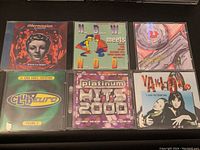Top view of six vintage music CD jewel cases showing front cover artwork and titles.