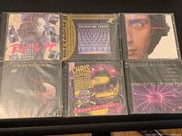 Front view of 6 sealed vintage music CDs showing a variety of album cover art.