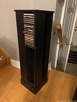 Front angle view showing the CD holder loaded on one side with CDs, highlighting the vertical slots for CD placement and the swivel mechanism.