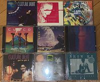 Photo showing nine music CDs arranged in three rows, front covers visible. Includes albums by Culture Beat, Hammer Dance, Loft, Curco, and others.
