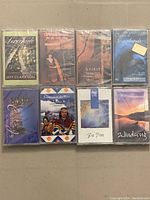Front view of eight sealed cassette tapes arranged in two rows showing cover art and titles.
