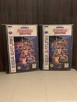 Two SEGA Saturn Shanghai Triple Threat game cases side by side, showing front covers.