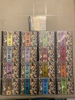 Photo showing 17 jewel case CDs arranged in 4 rows, colorful spines with volume numbers and 'Have A Nice Day' text.