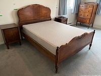 Full view of the vintage wooden bed frame with mattress, headboard, footboard, and side rails visible.