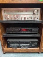 Shelf with three audio components stacked: top Pioneer receiver, middle JVC CD player, bottom Kenwood cassette deck